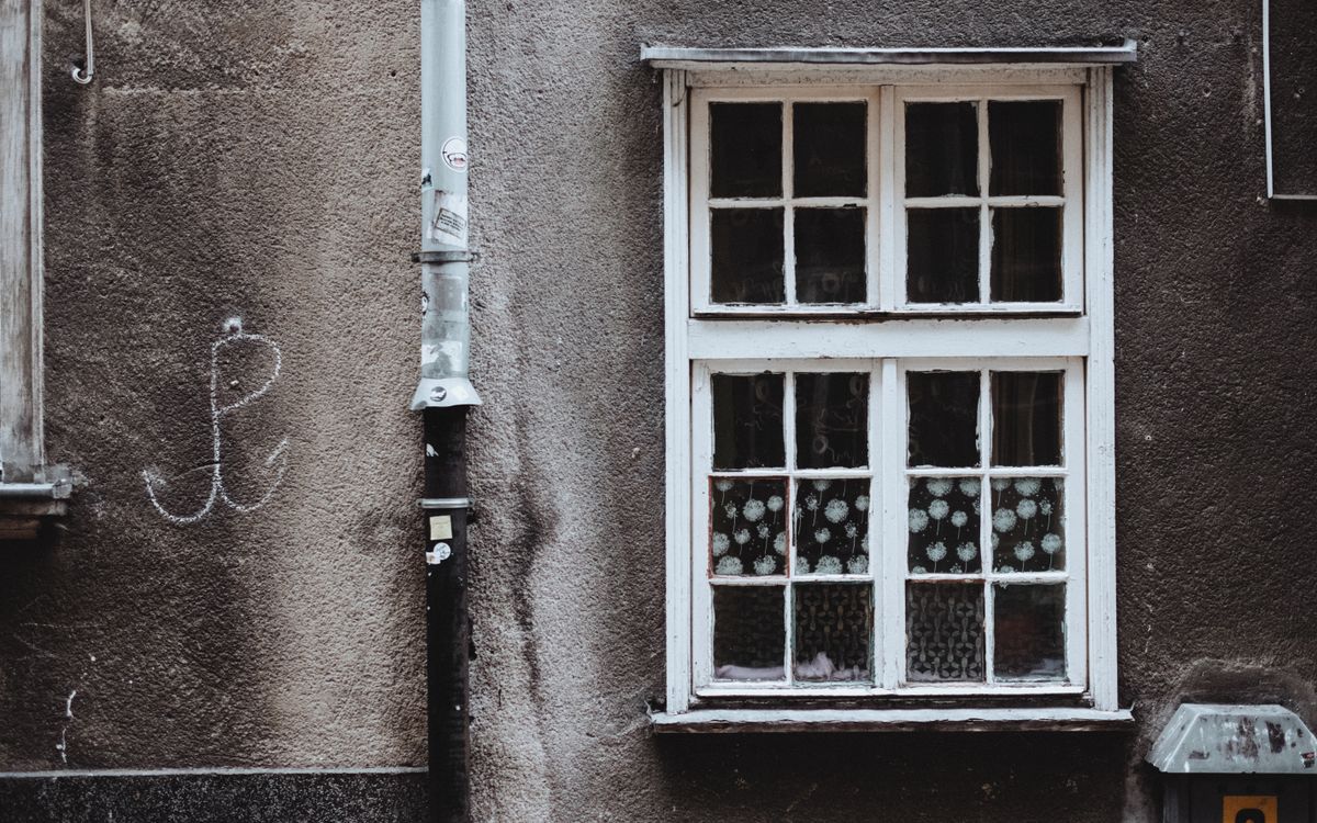 Zabrudzona spalinami elewacja budynku przy ruchliwej ulicy w mieście